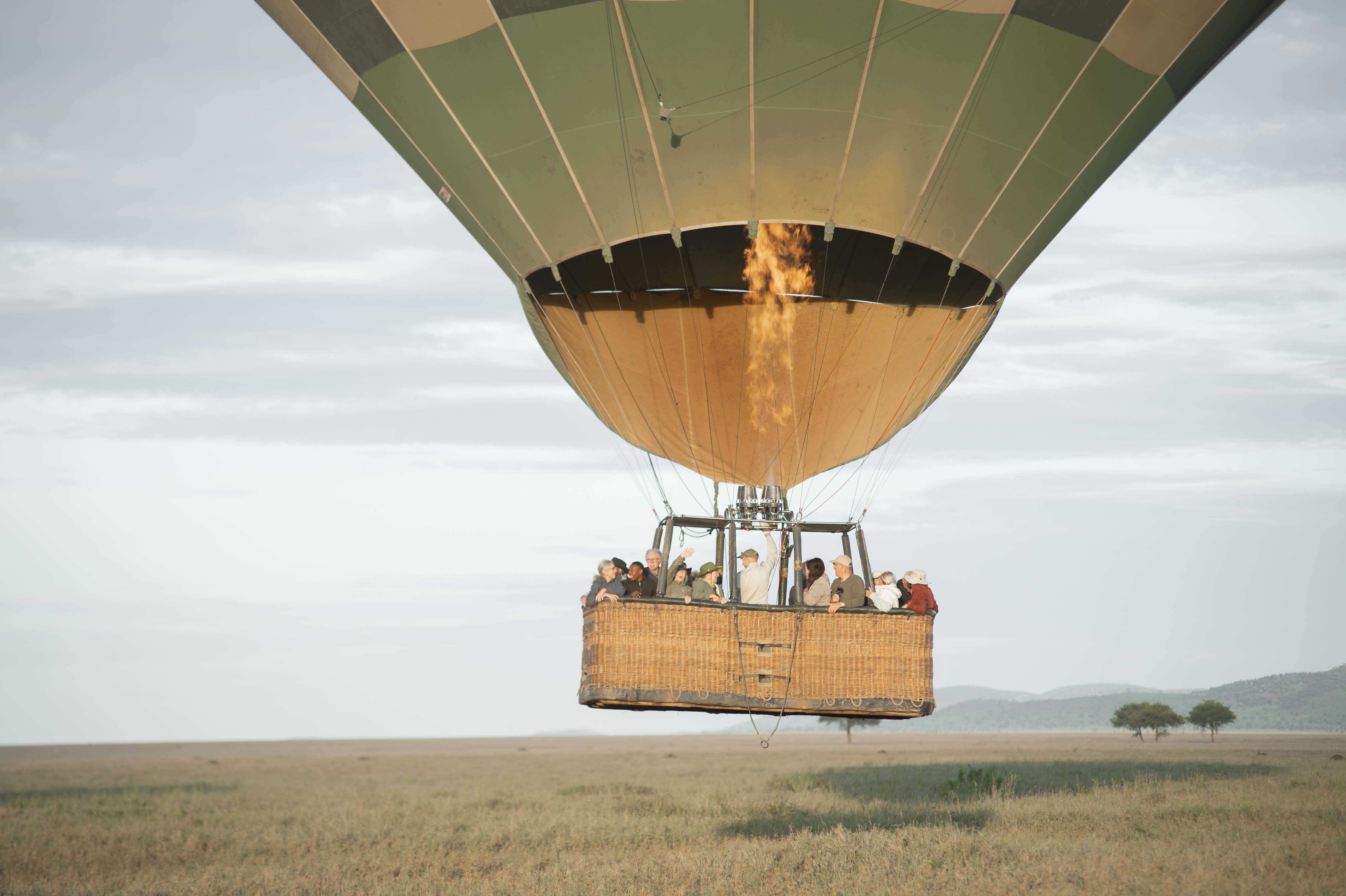 A hot air balloon safari rising over the Serengeti at dawn