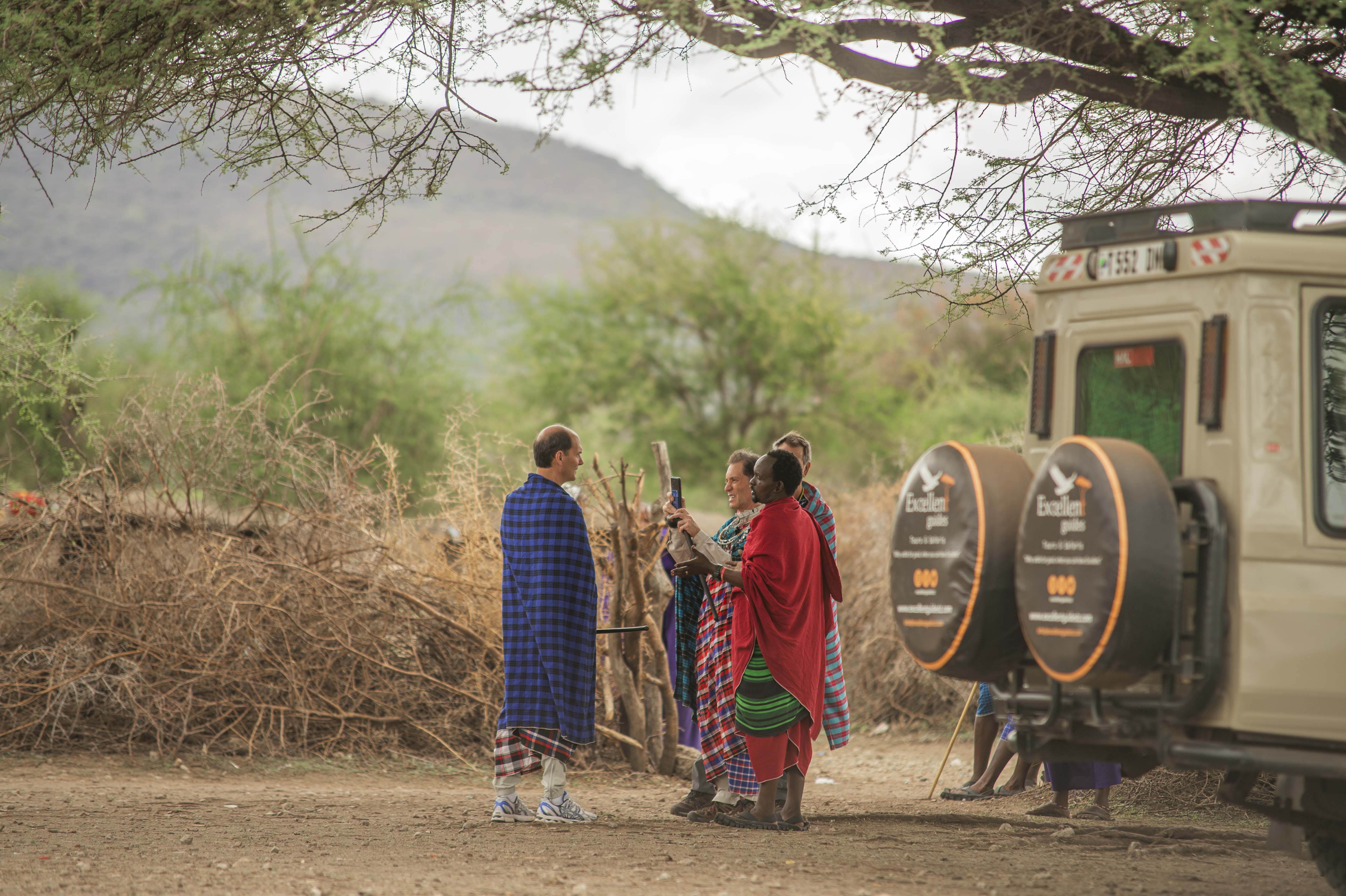 Guests gathering beside a hot air balloon before sunrise
