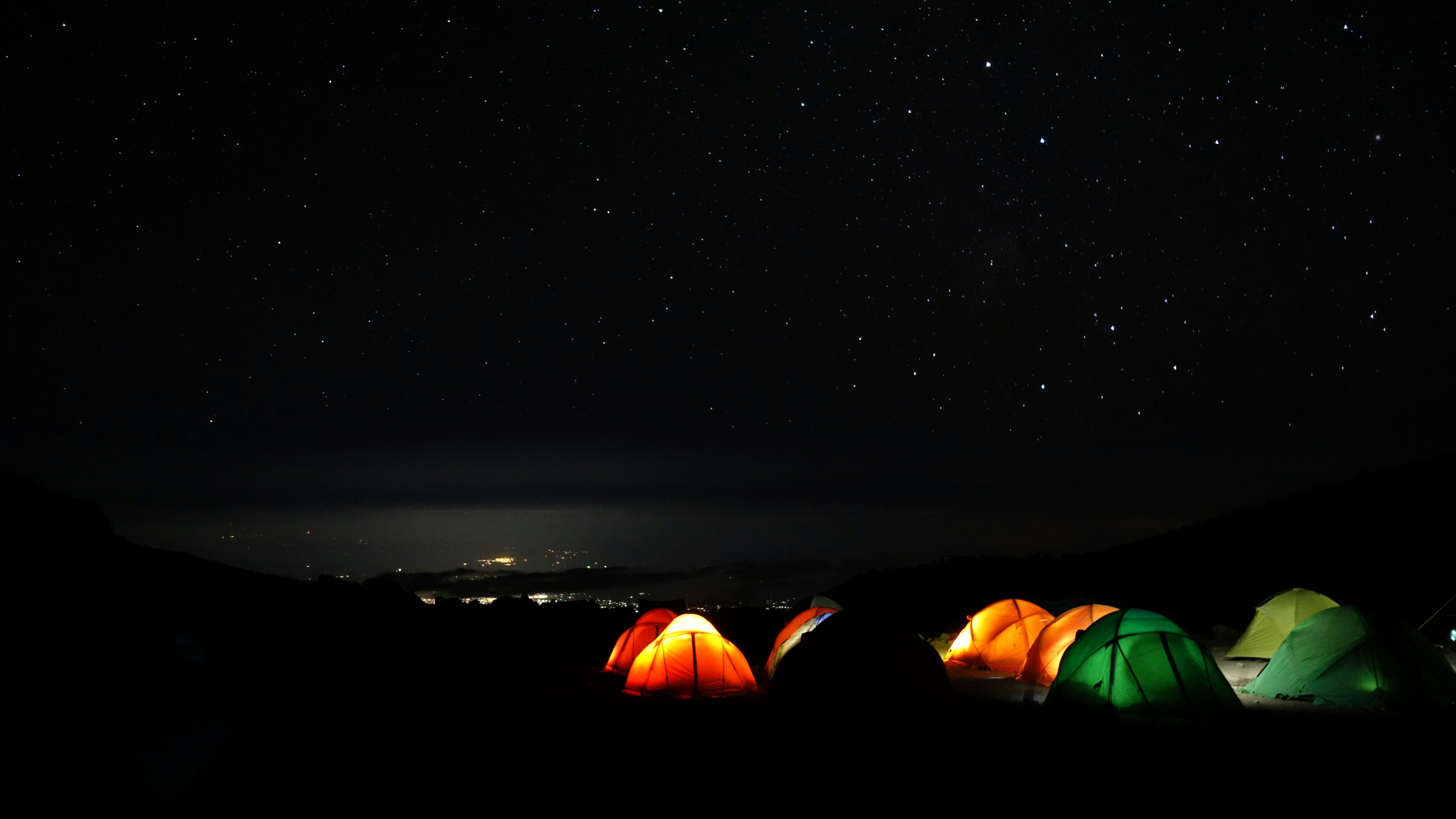 A refined Kilimanjaro camp glowing beneath a star-filled night sky