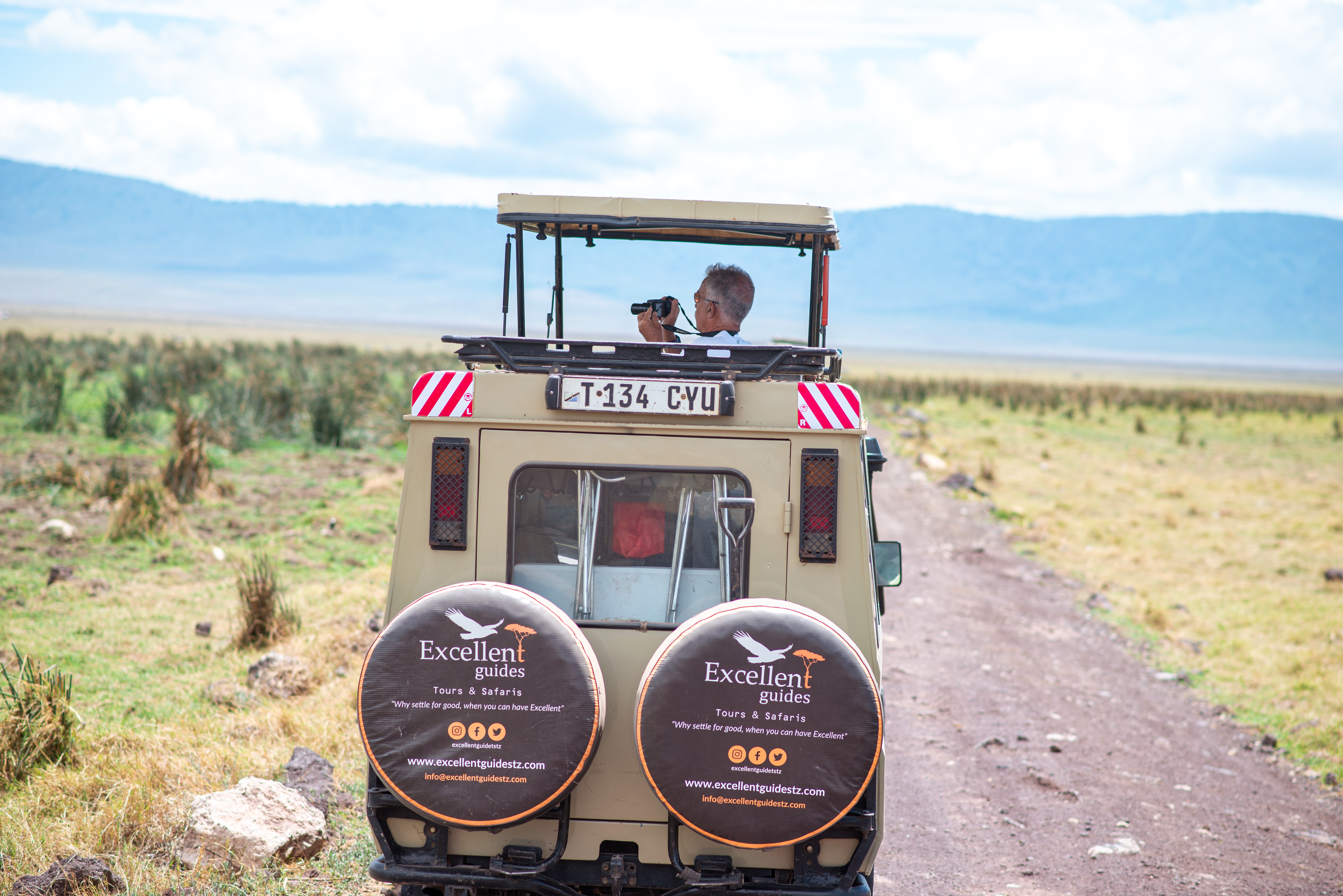 Guest photographing the landscape from an Excellent Guides safari vehicle