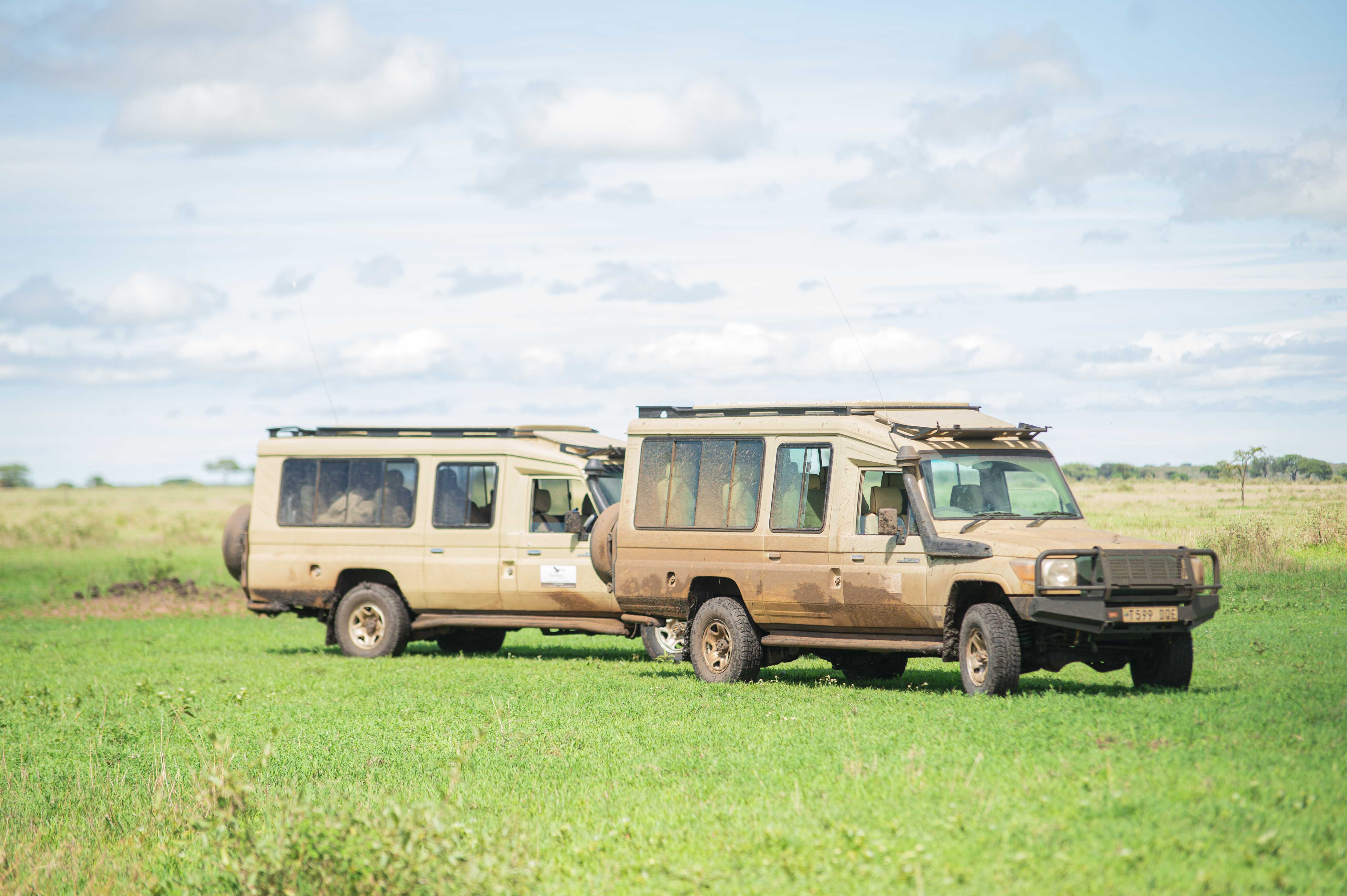 Two Excellent Guides safari Land Cruisers in open grassland
